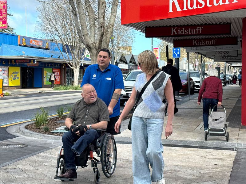 People on a footpath, one person in a wheelchair